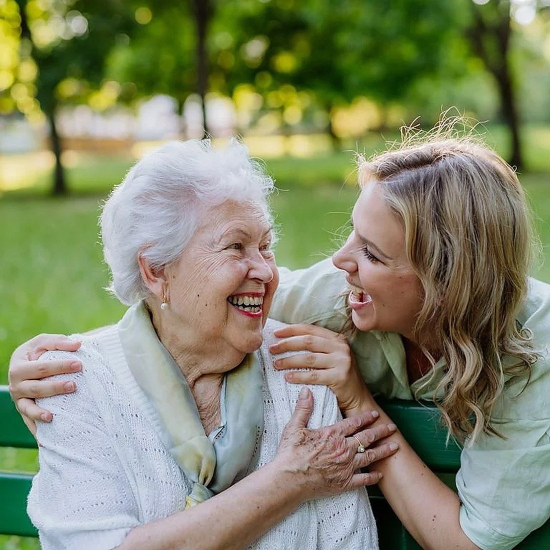 Warm companionship: a carer and an elderly woman laughing together
