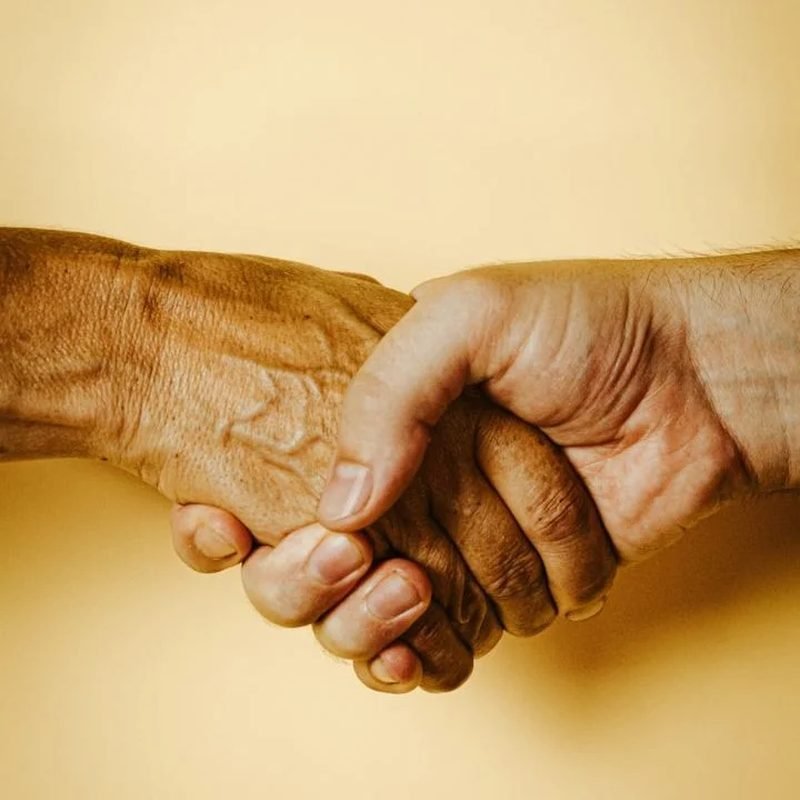 Pflegekraft unterstützt einen Senior bei Bewegungsübungen